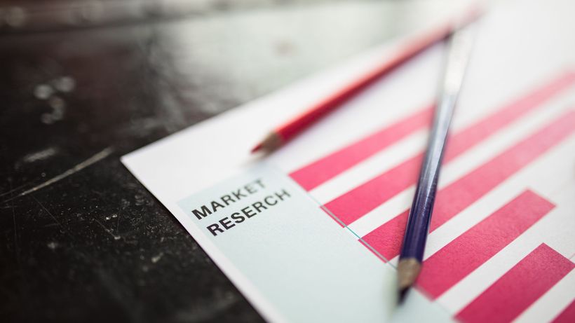 Close-up of market research paper with red graph bars and pencils, emphasizing business analysis