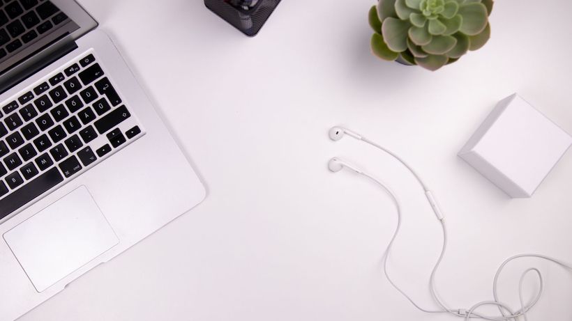 A clean workspace featuring a laptop, succulents, and earphones, perfect for remote work inspiration