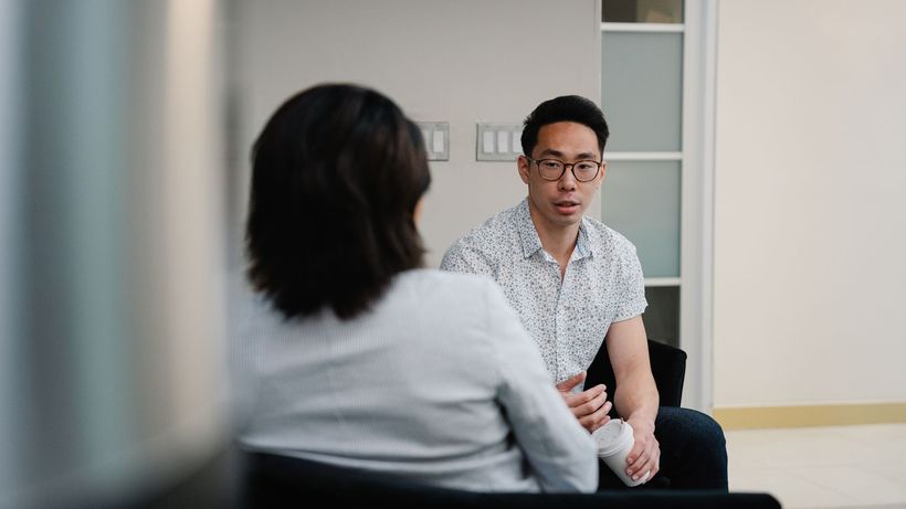 Two colleagues having a focused conversation in an office setting