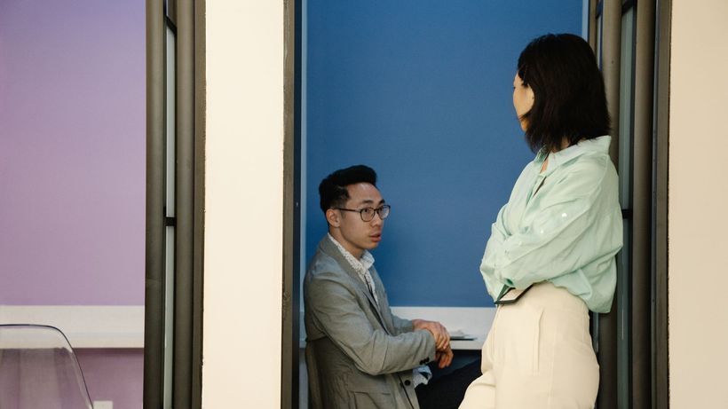 Two colleagues engaging in a conversation in a stylish and modern office setting