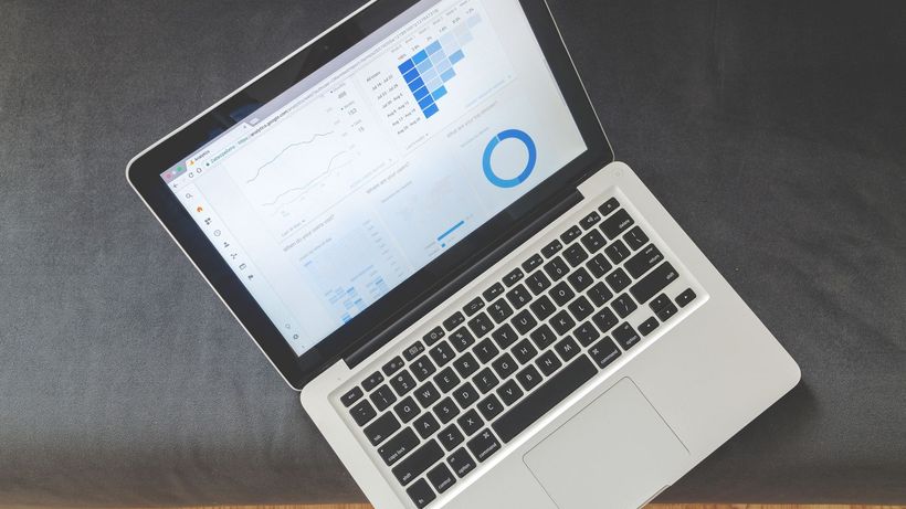 Overhead view of a laptop showing data visualizations and charts on its screen