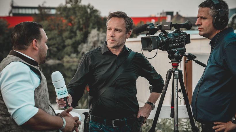 Outdoor interview with a professional news crew capturing footage using high-tech equipment