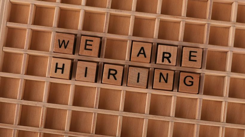 Wooden tiles on a board forming the phrase 'We Are Hiring', ideal for job announcements