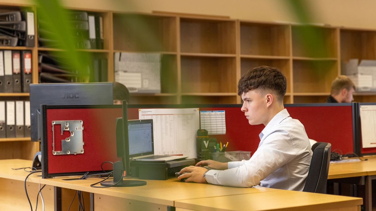 Entry-level SEO jobs: a focused young man typing on a computer in a contemporary office environment