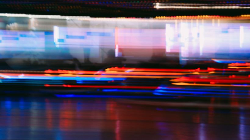 Capture of vibrant neon light streaks forming abstract patterns in a motion blur during long exposure