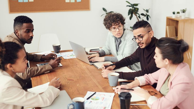 A diverse group of professionals engaged in a collaborative team meeting at the workplace