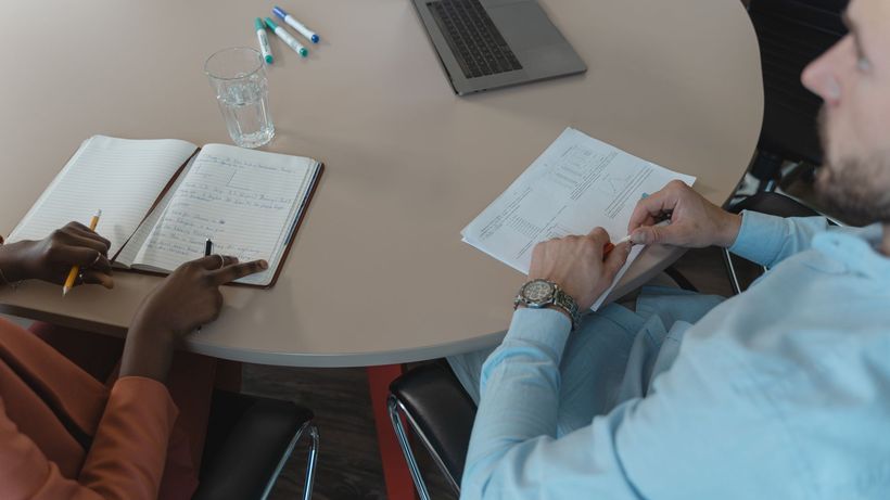 Business professionals collaborating over documents and laptops during a meeting