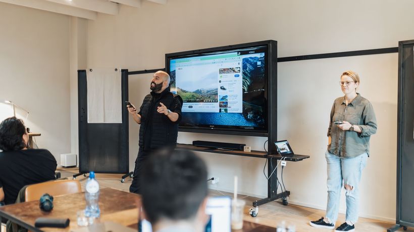 A team presentation in an office with a screen showcasing work-related material