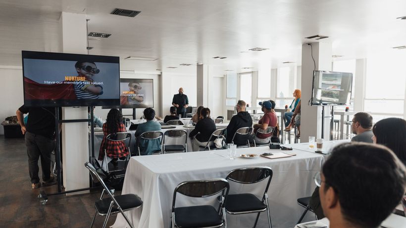 Speaker presenting to a diverse audience at a modern indoor conference setting