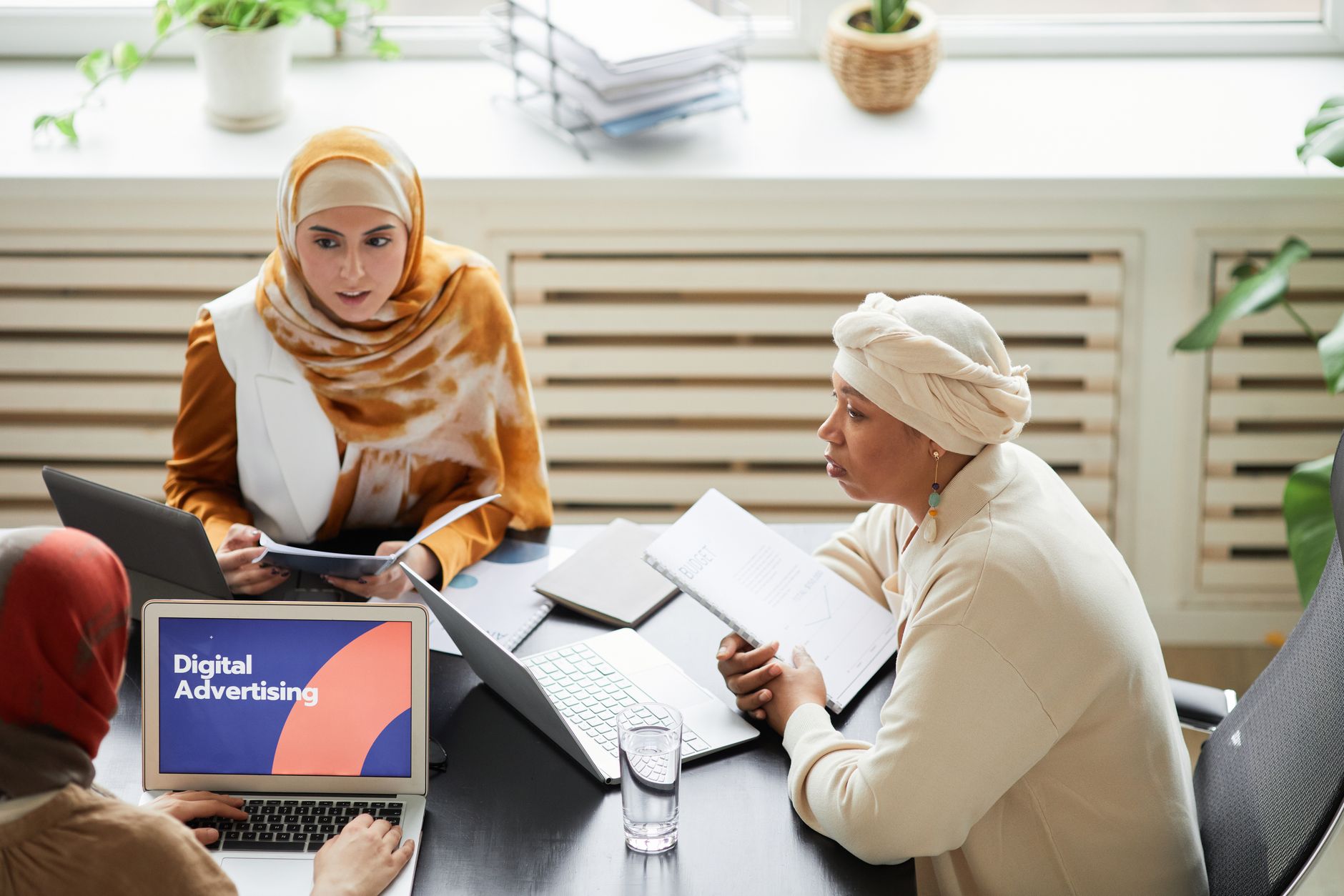 Marketing team reviewing SEO campaign performance on laptops in an office