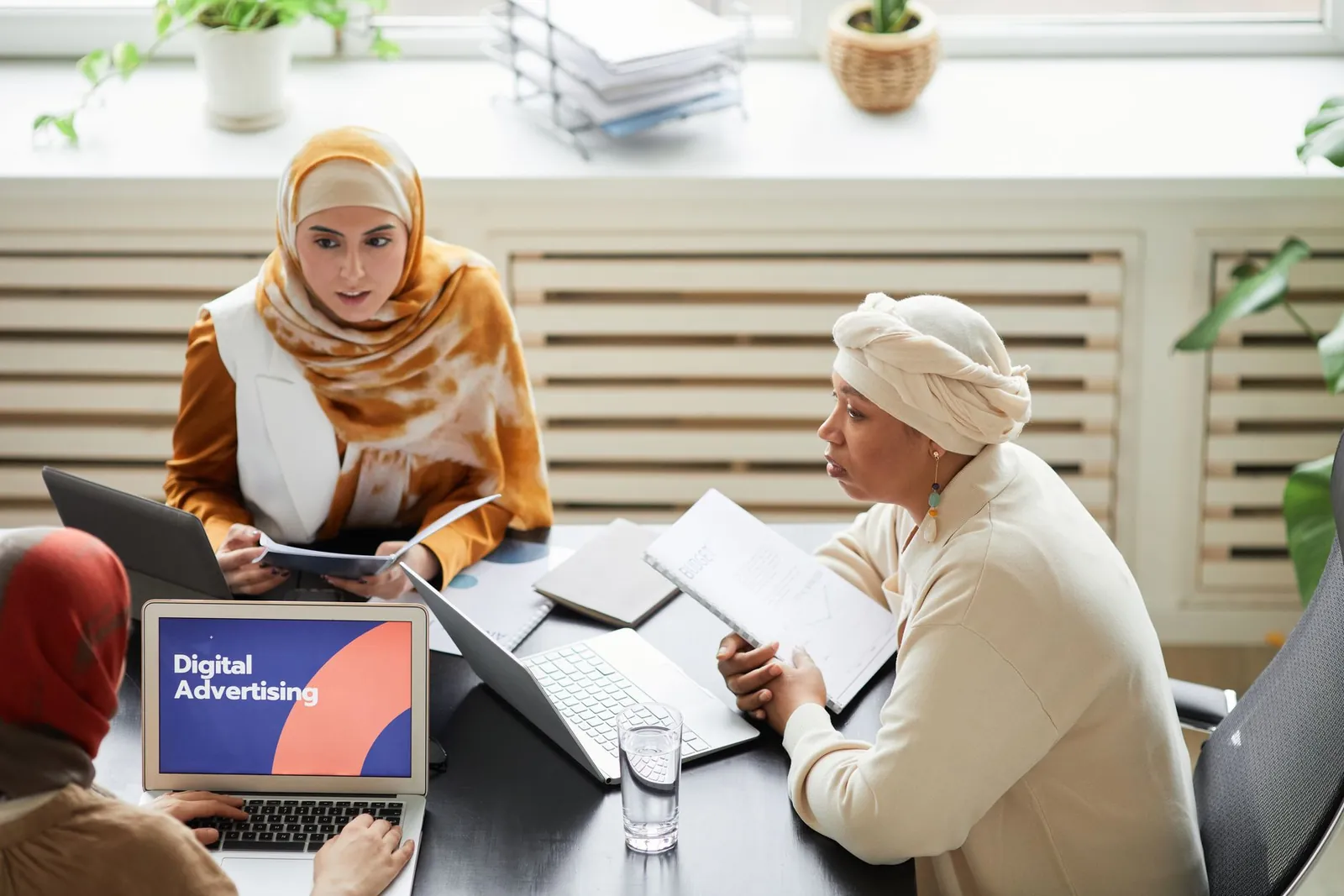 Marketing team reviewing SEO campaign performance on laptops in an office