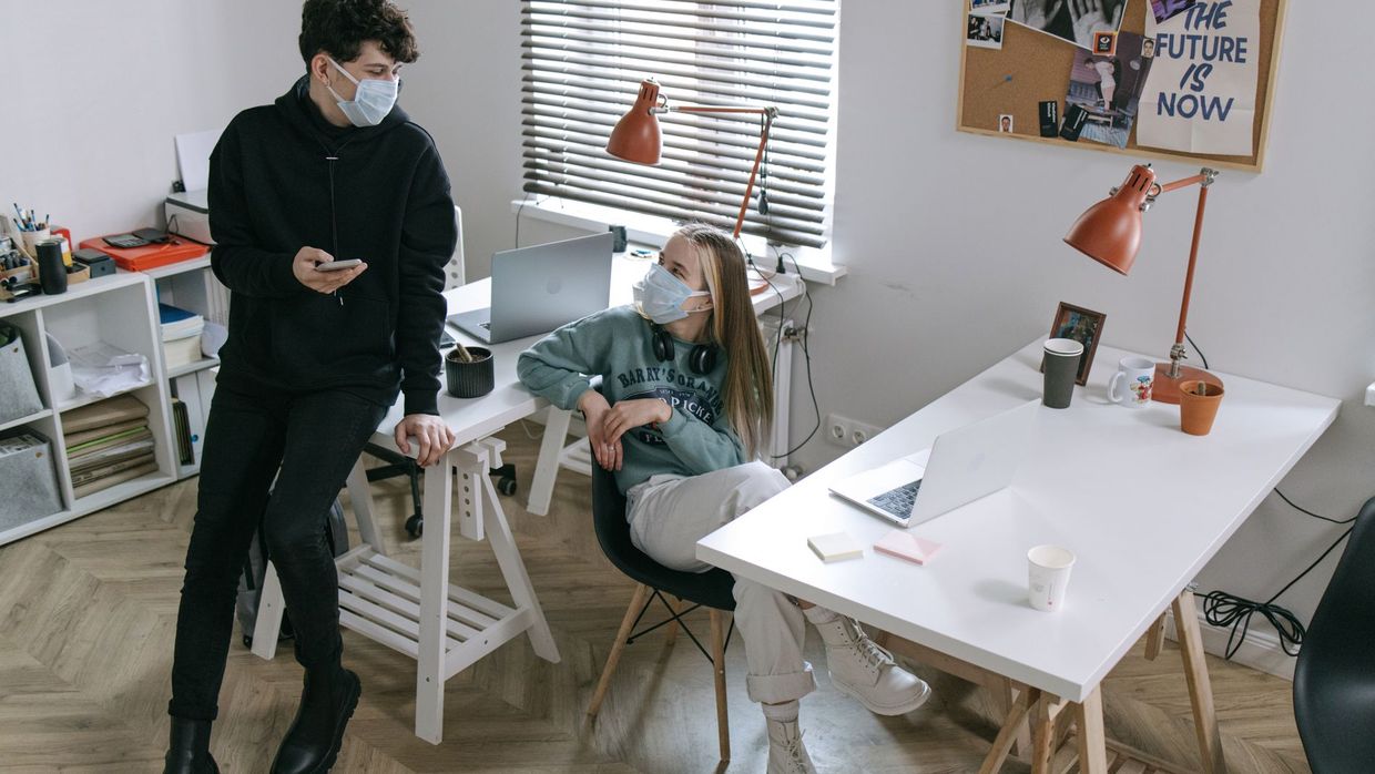 SEO careers: young professionals wearing masks working at a modern office desk during COVID-19