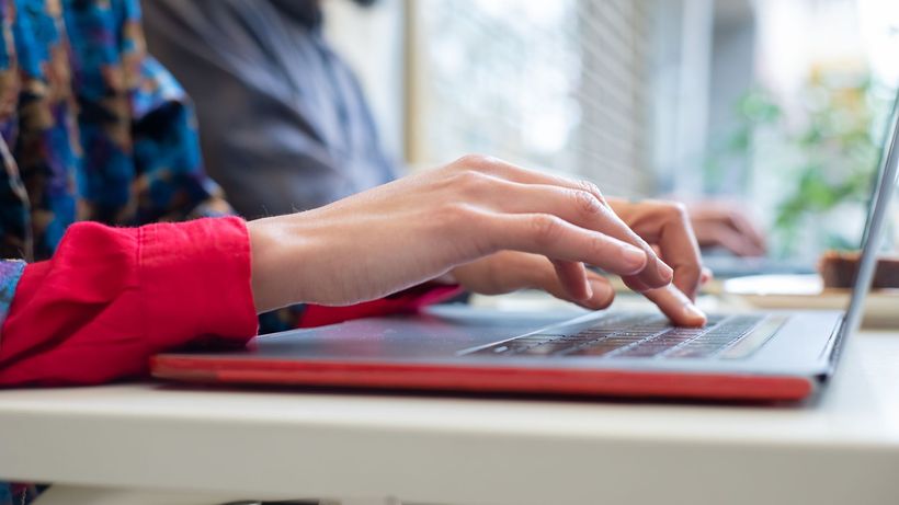 Person typing on a laptop indoors in Portugal, showing productivity and technology use
