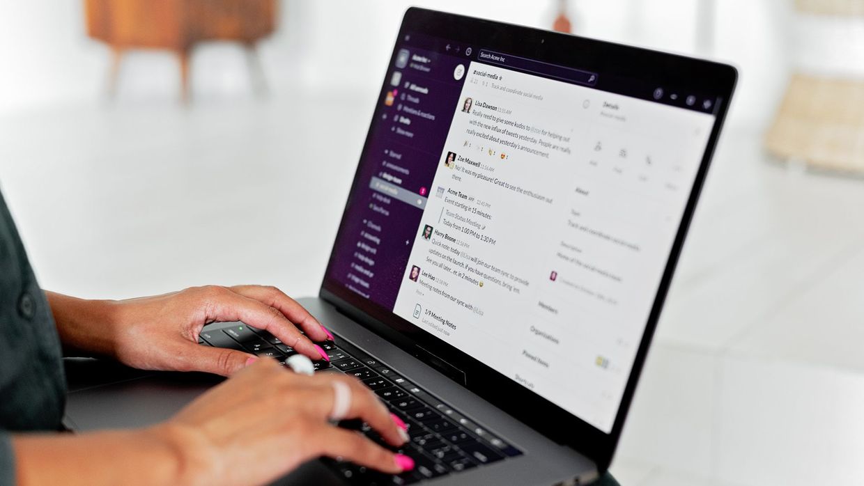 Link building: a woman types on a laptop using a messaging app in a modern office setting