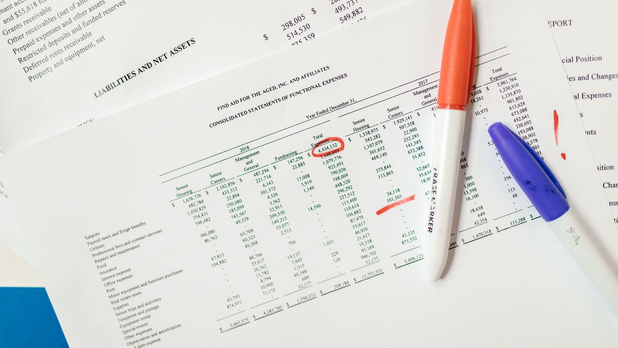 Salary data methodology: close-up of financial documents with highlighted figures and marker pens