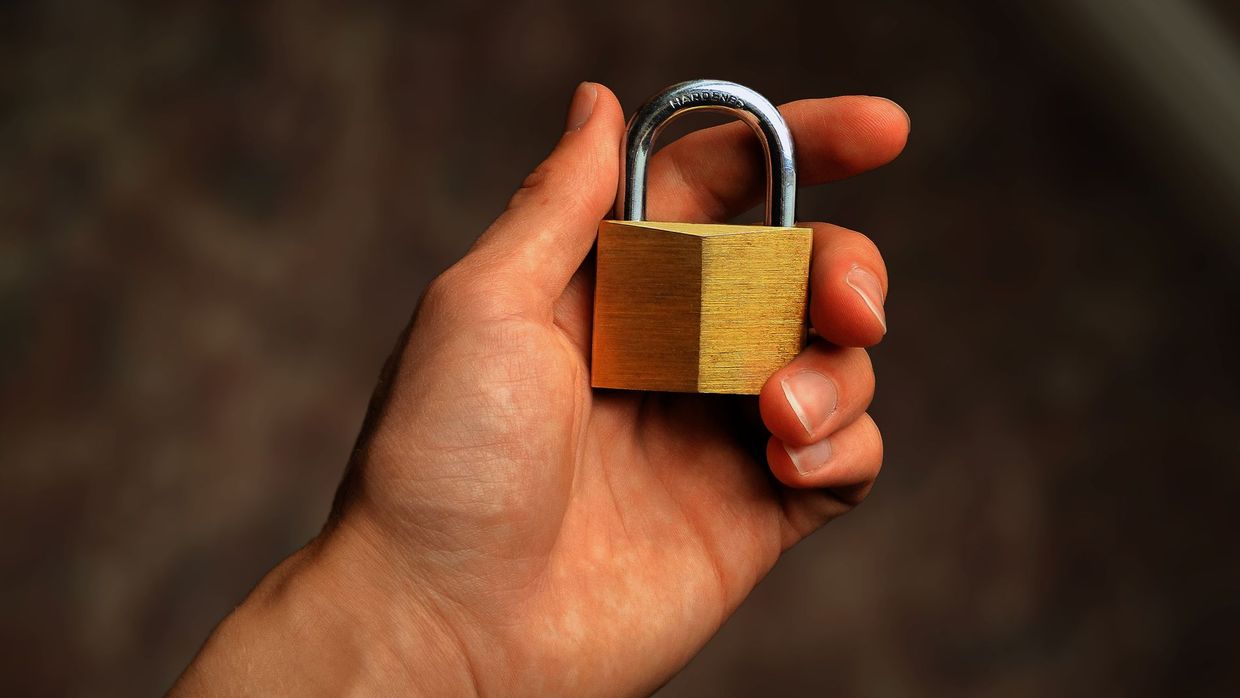 Privacy: hand holding a brass padlock, symbolizing security and protection