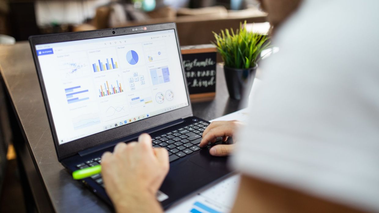 Programmatic SEO: focused business analysis with charts and graphs on a laptop in a modern office setting
