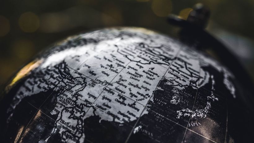 Detailed black and white close-up image of a globe focusing on Asia, highlighting geographical details
