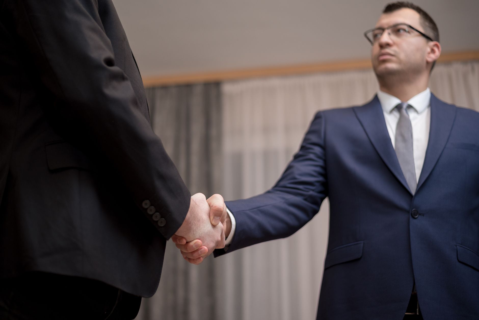 Two professionals shaking hands after a deal