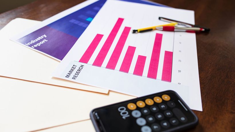 Illustrative market research chart and calculator on wooden desk for business analysis