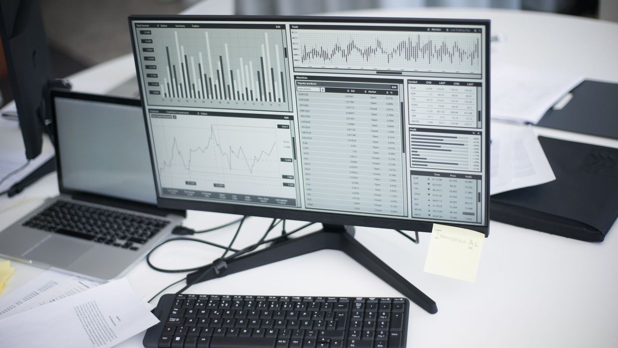SEO analyst pay: a professional workspace featuring computers and analytical graphs on a monitor, symbolizing modern