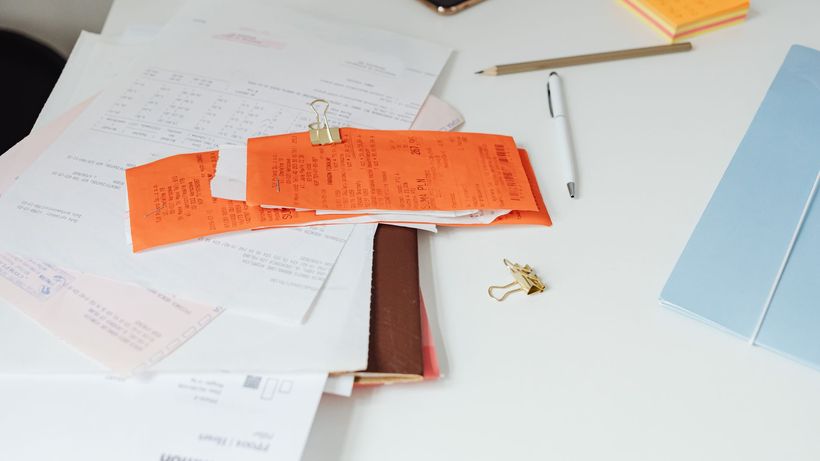 Close-up of a tidy desk with receipts, documents, and office stationery for business organization