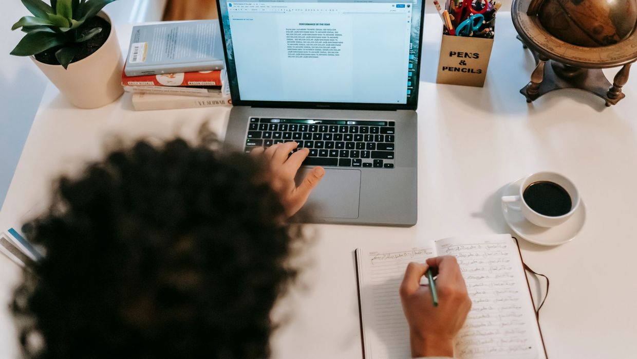 The SEO content strategist role: from above of anonymous writer using portable computer with text on screen at table