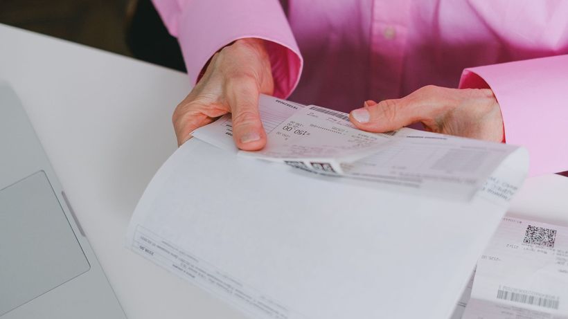 Business person handling paper receipts, meticulously organized