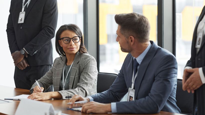 Diverse business professionals discussing strategy during a modern board meeting