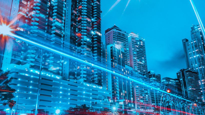 Colorful cityscape of illuminated skyscrapers and dynamic light trails at night