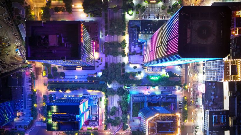 Stunning aerial view of illuminated city buildings at night with colorful lights