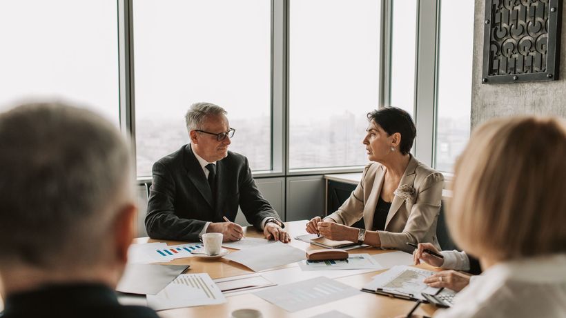 Business professionals engaged in a strategic meeting in a modern office setting with natural light