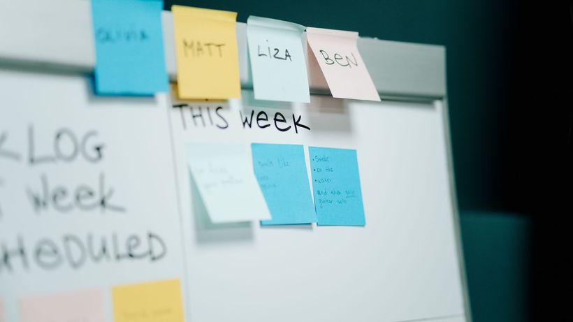 Close-up of a whiteboard with colorful sticky notes for task organization and planning