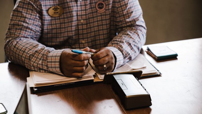 A businessman with documents, organizing and working at his desk for an office task