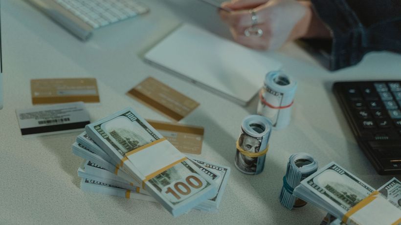 Close-up of dollar bills and credit cards on a desk, symbolizing financial transactions