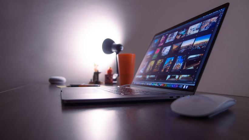 A sleek desk setup featuring a laptop, desk lamp, and accessories