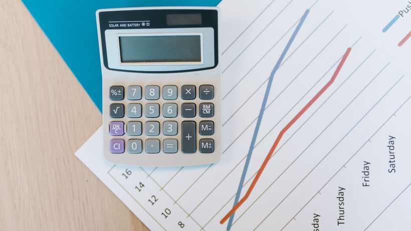 Top view of calculator and graph paper on office desk, perfect for business themed visuals