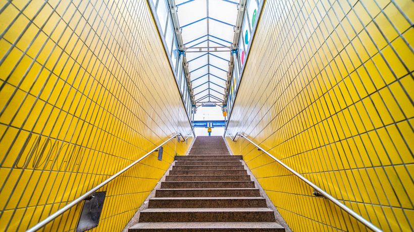 Low angle view of vibrant yellow tiled stairway leading upwards indoors