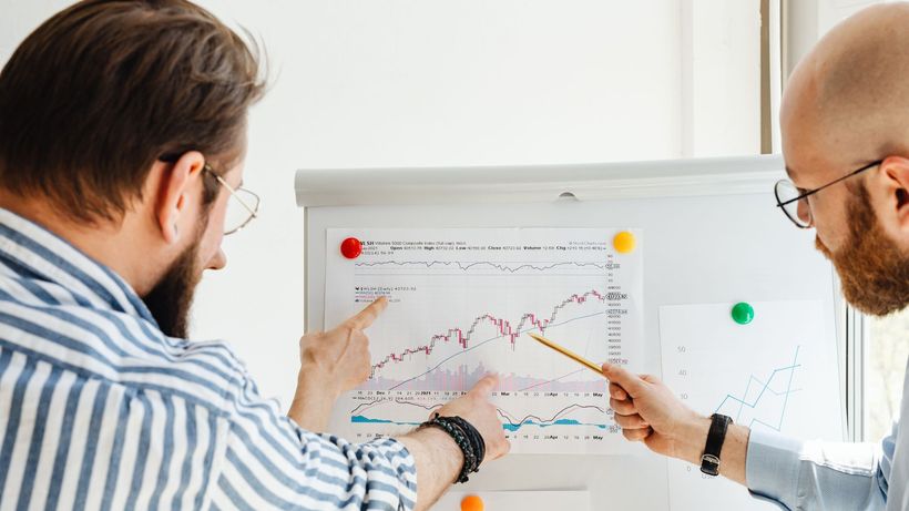 Two business professionals analyzing financial charts during a daytime meeting