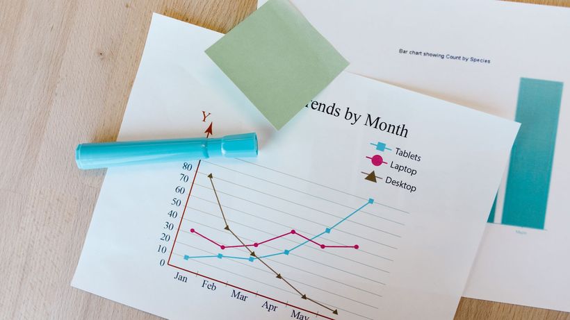 Desk with colorful graphs, sticky notes, and a marker, perfect for data analysis themes