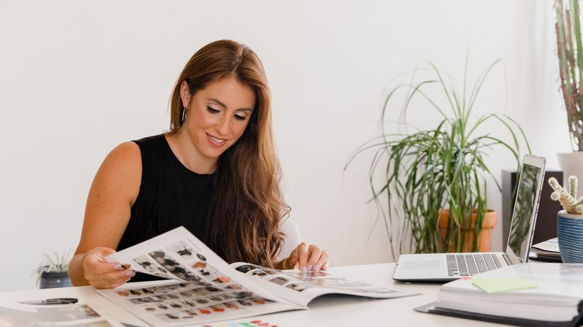 Businesswoman analyzing design portfolio in modern office setting