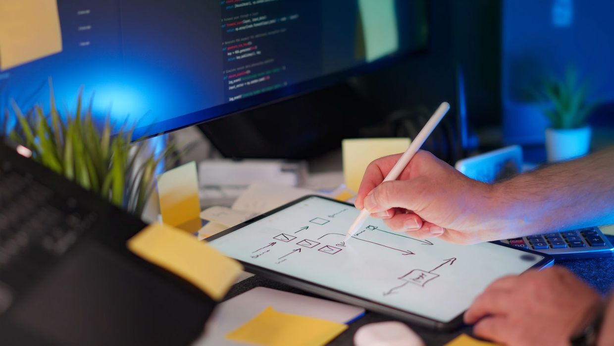 SEO versus UX design: a vibrant workspace featuring digital sketching on a tablet and code on a monitor, showcasing