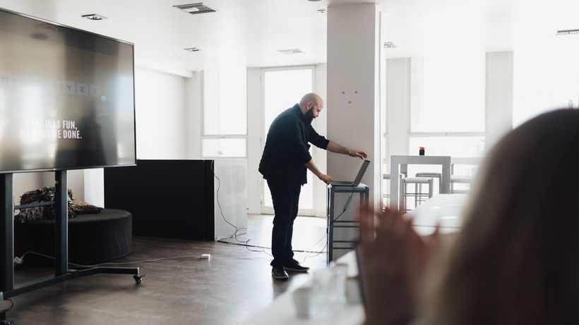 Professional presentation setting with a screen and laptop, captured indoors