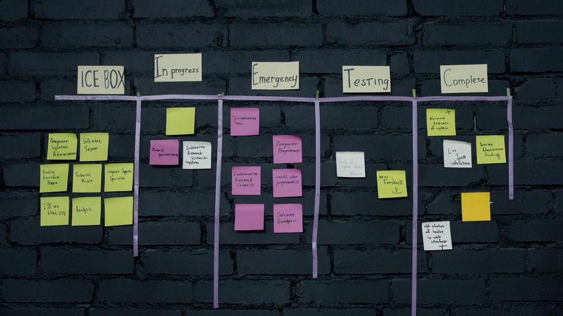 Top-down view of an office Kanban board with colorful sticky notes for task management and organization