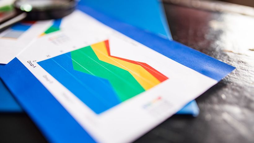 Close-up of a colorful business chart placed on a table with documents highlighting trends